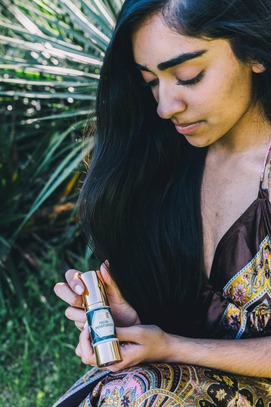 A woman holding the Generation Bee facial moisturizer pump bottle